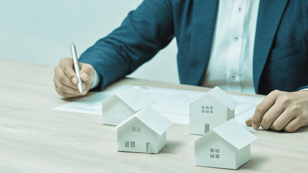 como avaliar uma casa durante análise imobiliária com miniaturas de imóveis e documentos